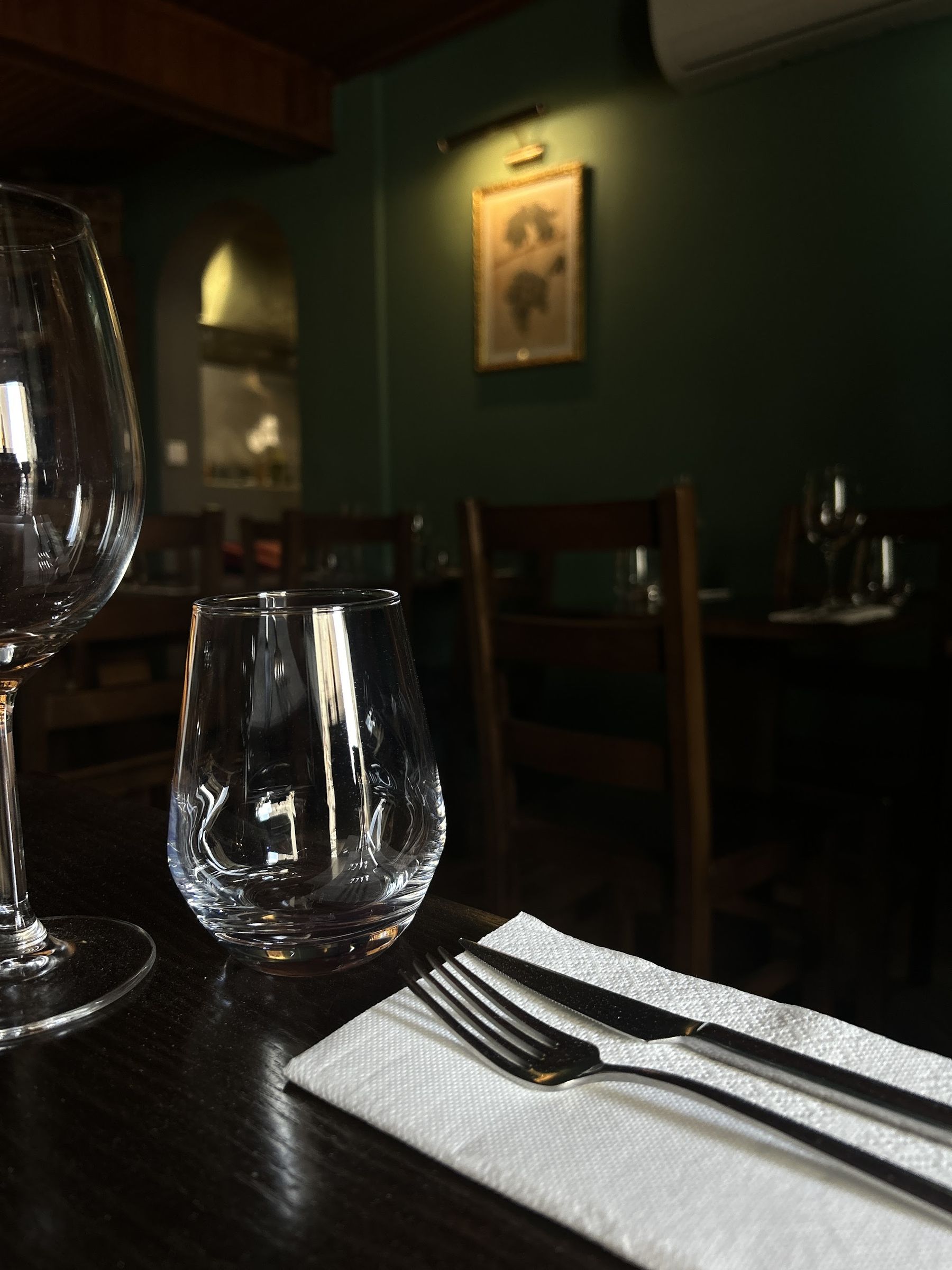 Copo de vinho, guardanapo e faca sobre mesa de madeira